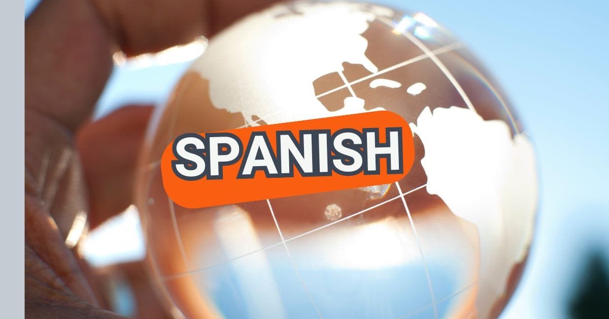 Hand holding a crystal clear ball with the international world map on it, and the word "Spanish".